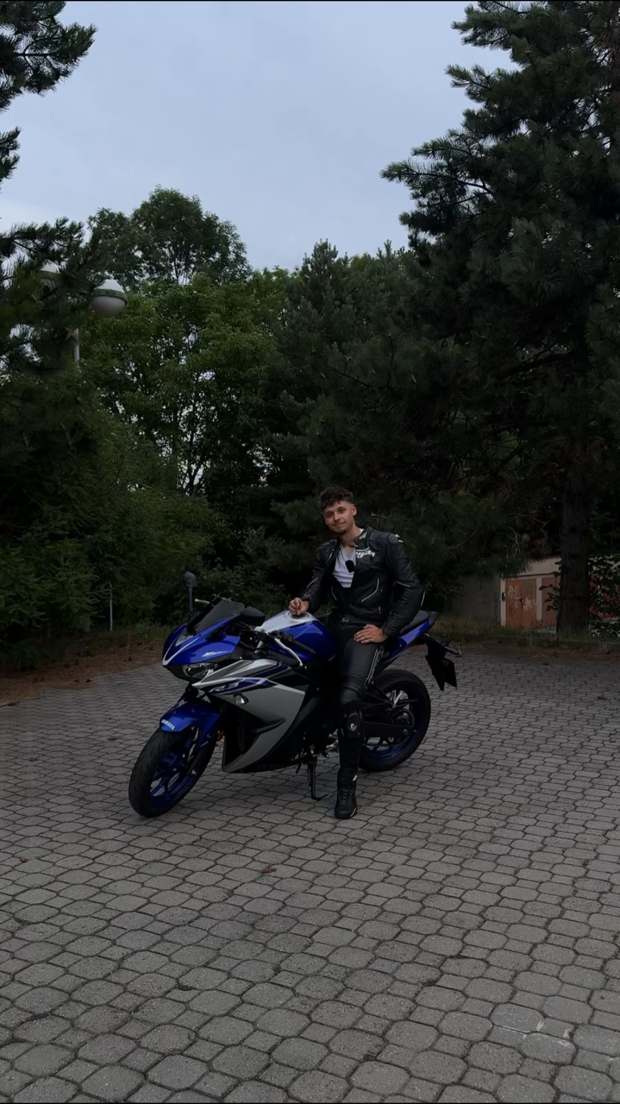 Jakub v kožené kombinéze sedí na modré Yamaze R3